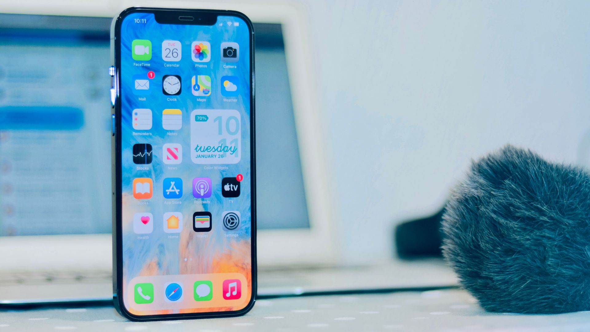 An iphone sitting on a desk next to a microphone