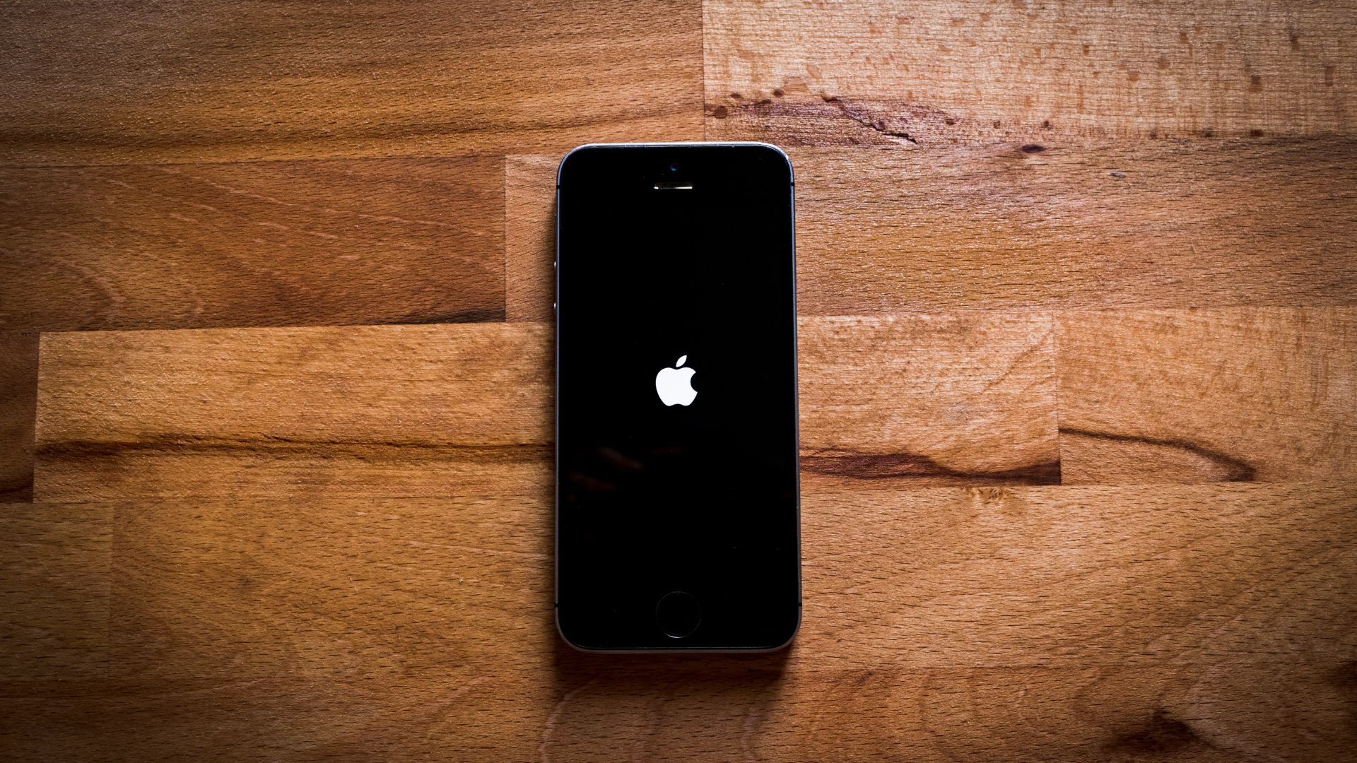 An iphone sitting on top of a wooden table