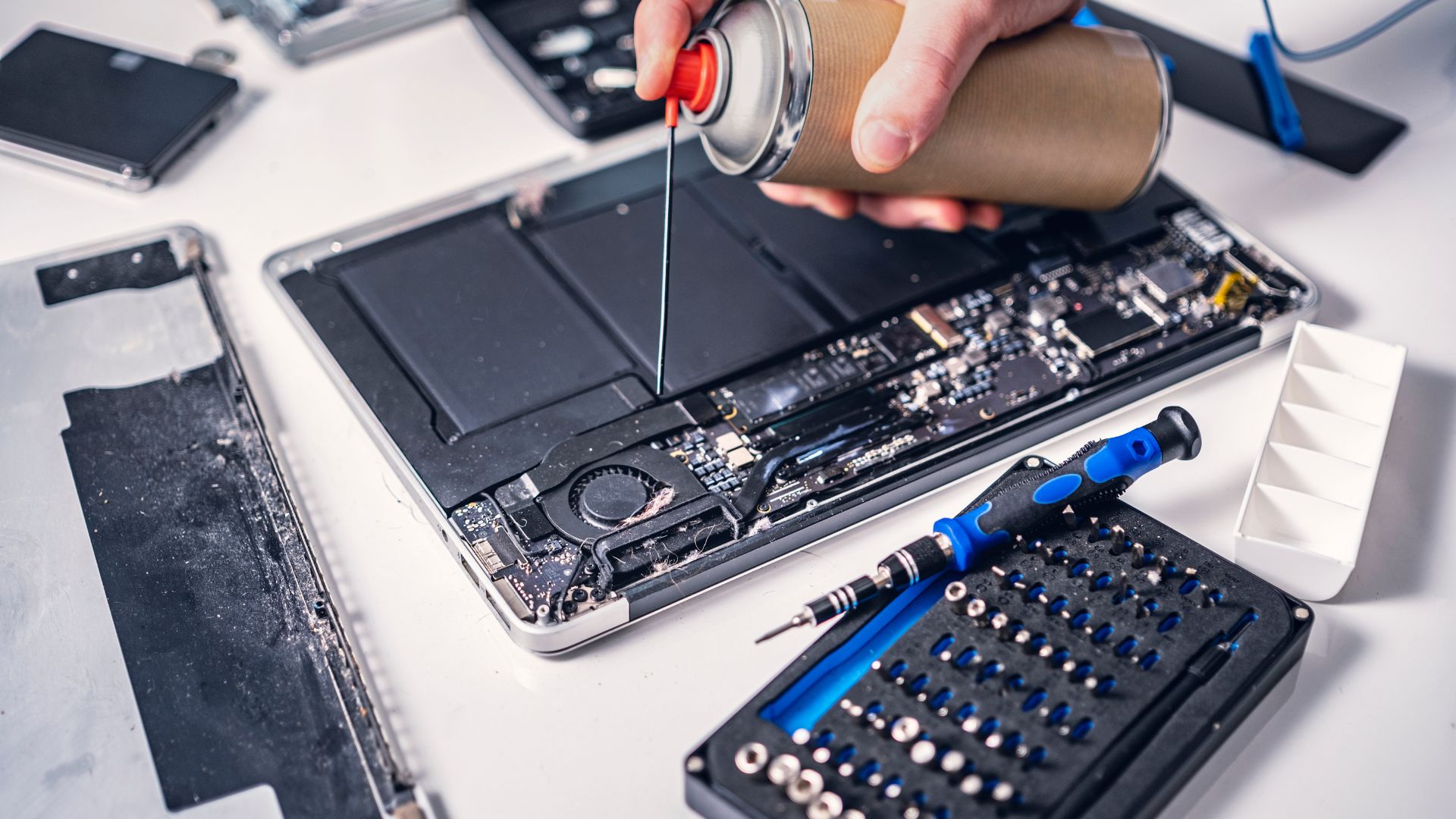 A person using a screwdriver to fix a laptop