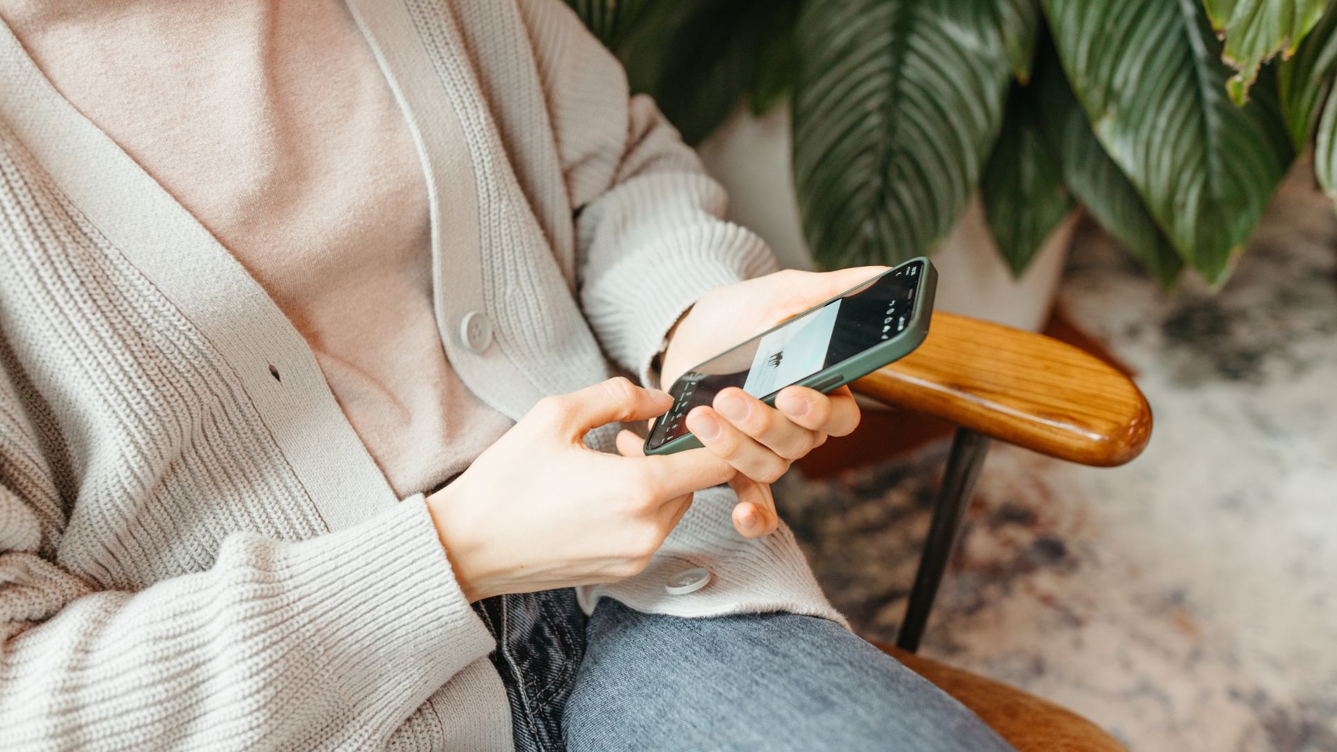 A woman sitting on a chair holding a cell phone